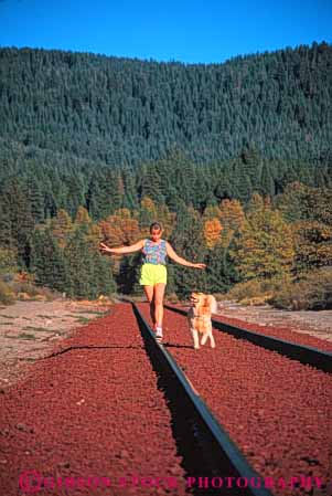 Stock Photo #5582: keywords - alone animal balance calm companion conditioning dog exercise explore fit fitness friend hike hiking mammal move outdoor outdoors outside peaceful pet physical physically quiet railroad released rural solitary solitude summer track vert walk walker walking woman workout