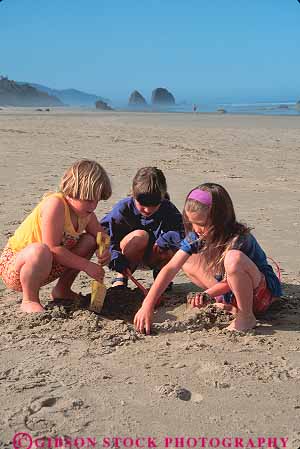 Stock Photo #13407: keywords - beach beaches cannon child children coast coastal dig digging digs friend friends girl girls group groups in kid kids landscape landscapes northwest ocean oregon people play playing plays released resort sand scenery scenic scenics sea shore shoreline shorelines summer vacation vert