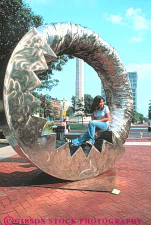 Stock Photo #9274: keywords -  asian circle circular cities city downtown england ethnic girls in island metal minority new play providence rhode riverpark round sculpture sculptures sit sits summer vert youth