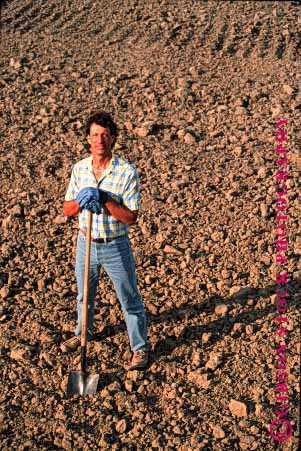 Stock Photo #1301: keywords -  agriculture california dirt earth employee farm farmer field in industry job lean leaning leans occupation plowed portrait released shovel soil stand standing turned unplanted vert worker