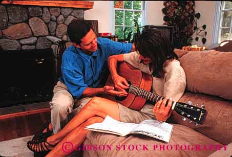 Stock Photo #1358: keywords -  affection art bond coordination couple finger guitar home horz house husband instrument learn listen love man model music musician perform play practice quiet released security share skill sound spouse stringed student teach together wife woman