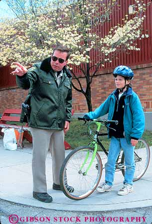 Stock Photo #10941: keywords -  assist assisting bicycle bicycling bicyclist bike child course direct direction directs girl girls point points police policeman policemen public recreation safe safety service teach teacher teaching vert youth