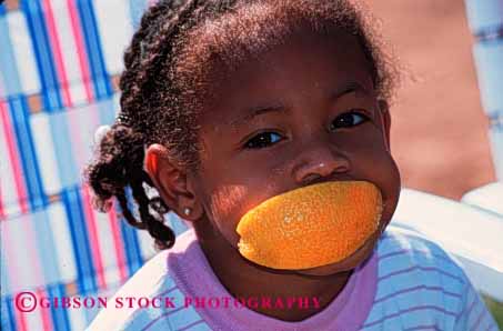 Stock Photo #1934: keywords -  african american black child citrus cute eat face food fruit girl horz humor mouth not orange released slice