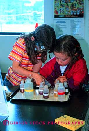Stock Photo #1964: keywords - chemical chemistry couple experiment girls goggles laboratory learn not observe released safety science team together vert