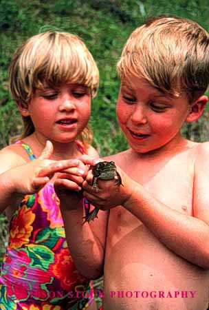 Stock Photo #2001: keywords -  amphibian animal boy child children examine frog gentle girl hold look model outdoor released study touch vert wet