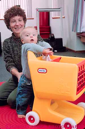 Stock Photo #14643: keywords -  assist assisting assists babies boy bright career child children color condition conditioning down heal healer healing health healthy help helper helping helps hold holding holds job jobs material physical plastic recover recovery released strengthen syndrome synthetic therapeutic therapist therapy toddler toddlers toy toys vert wagon with woman women work worker workers working works yellow