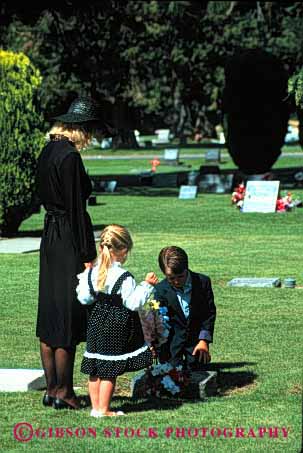 Stock Photo #2111: keywords -  black boy brother cemetery child children commemorate daughter dead death family flowers girl grave loss model mother mourn parent released remembrance sad sister son tribute vert visit widow wife