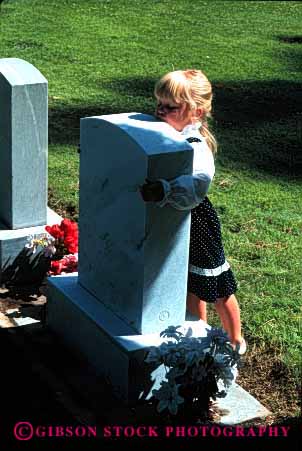 Stock Photo #2112: keywords - affection cemetery child commemorate daughter dead death family flowers girl grave gravestone hug loss model mourn parent released remembrance sad tribute vert visit