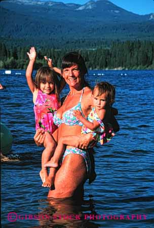 Stock Photo #2475: keywords - baby bathing carry child children daughter family female girl happy lake lift mother parent released single sister smile suit summer swim together vert warm wife woman
