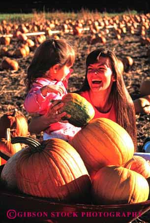 Stock Photo #2479: keywords -  autumn child daughter fall family female girl halloween happy intimate laugh mother orange parent pick pumpkin released single together vert warm wife woman