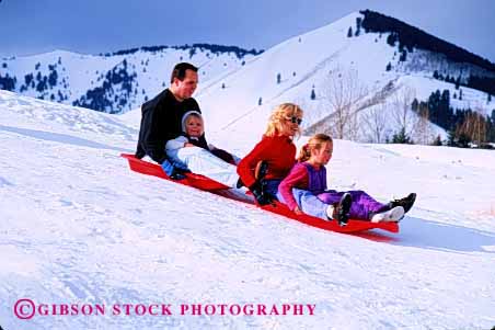 Stock Photo #2576: keywords -  child downhill family father fun gravity horz idaho mother motion parent plastic play recreation released share sled sledding slide snow sport sun together valley winter