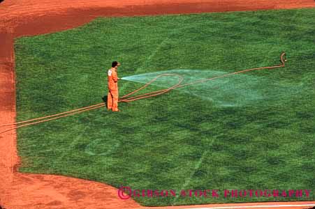 Stock Photo #2775: keywords -  baseball diamond grass green grounds horz hose irrigation job landscape man occupation water work