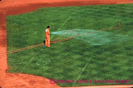 Stock Photo #2775: keywords - baseball diamond grass green grounds horz hose irrigation job landscape man occupation water work