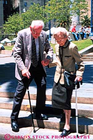 Stock Photo #6116: keywords -  assist canes careful caution citizen couple elderly help mature old senior seniors slow slowly step steps timers vert walk with