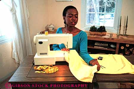 Stock Photo #4412: keywords -  african american black chore cloth clothes clothing craft create ethnic fabric female fix hobby home horz house household learn machine make minority mother released repair sew sewer sewing skill wife woman work