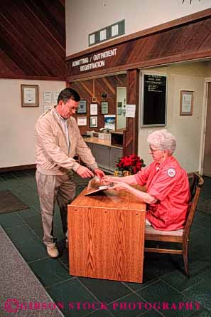 Stock Photo #4478: keywords -  admission admissions admitting elderly entrance greet health hospital lobby man mature medical medicine old patient reception released service staff vert volunteer woman