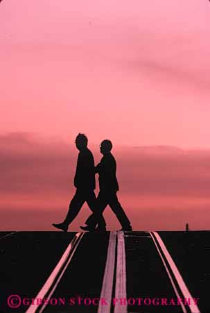 Stock Photo #5332: keywords -  across city cross man men move pair pavement pedestrians people road silhouette step street two vert walk walker walking